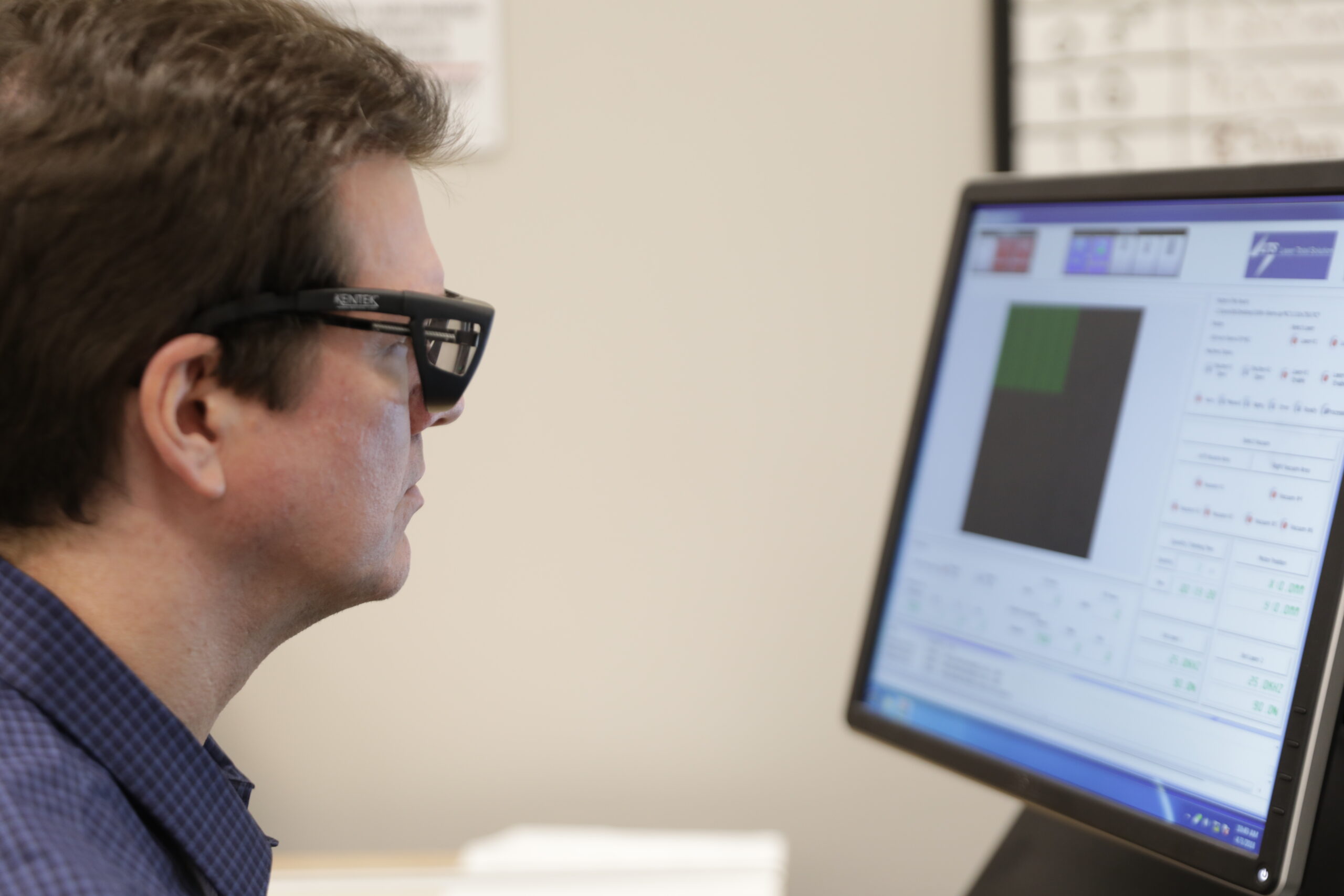 A person with short hair and glasses sits in front of a computer to work on a light guide design